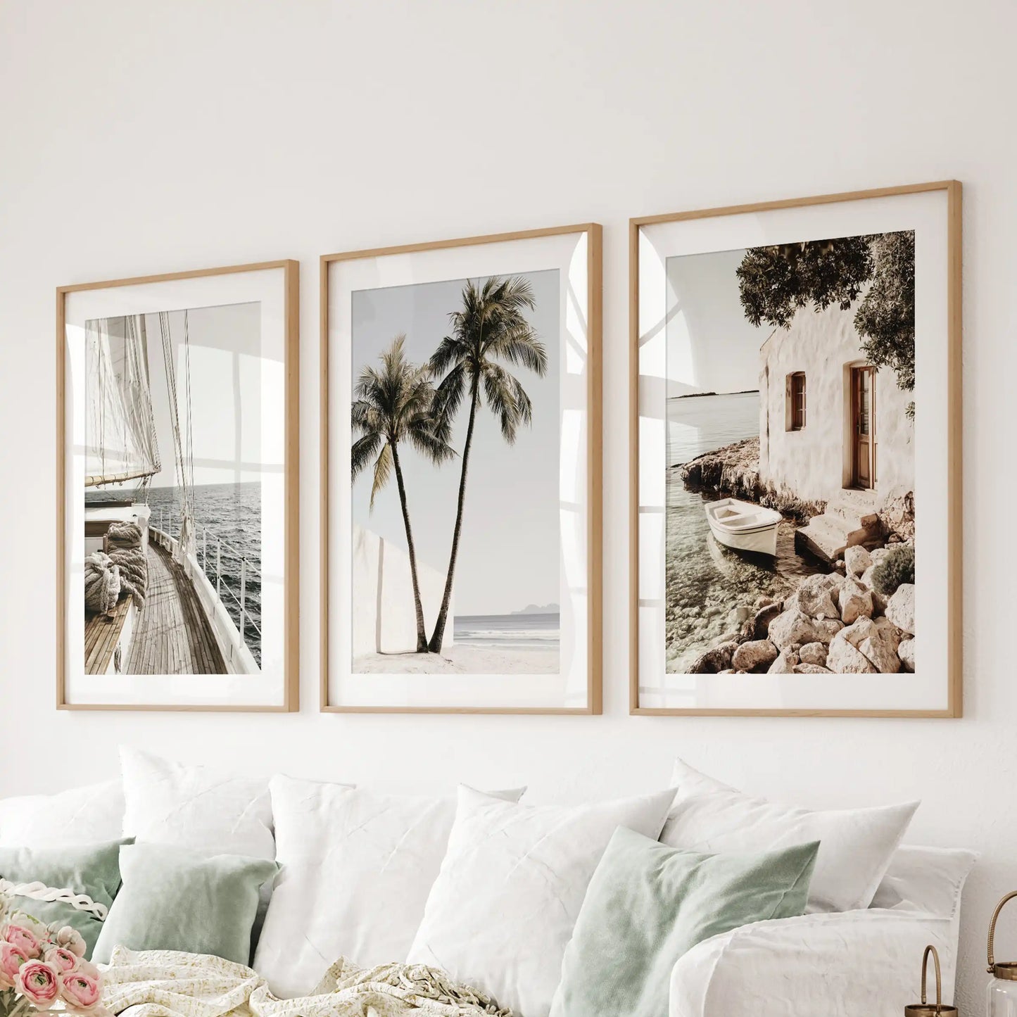Natural oak-framed sea photography wall art in a three-print set with mats hangs over the sofa, filling the family room with luminous blue tones.