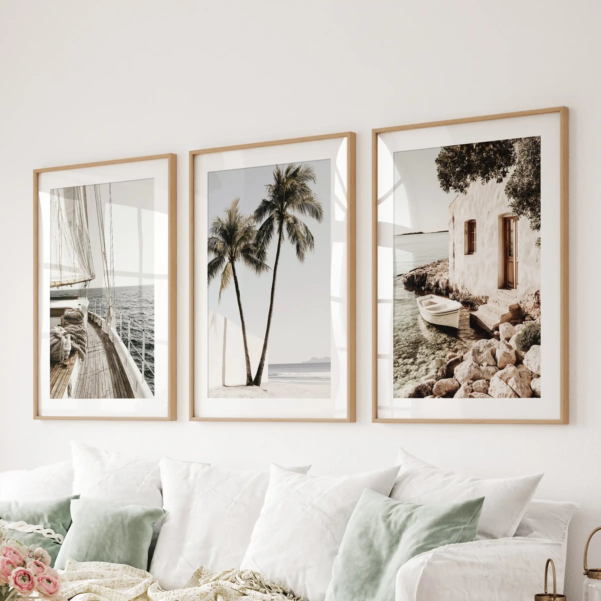 Natural oak-framed sea photography wall art in a three-print set with mats hangs over the sofa, filling the family room with luminous blue tones.