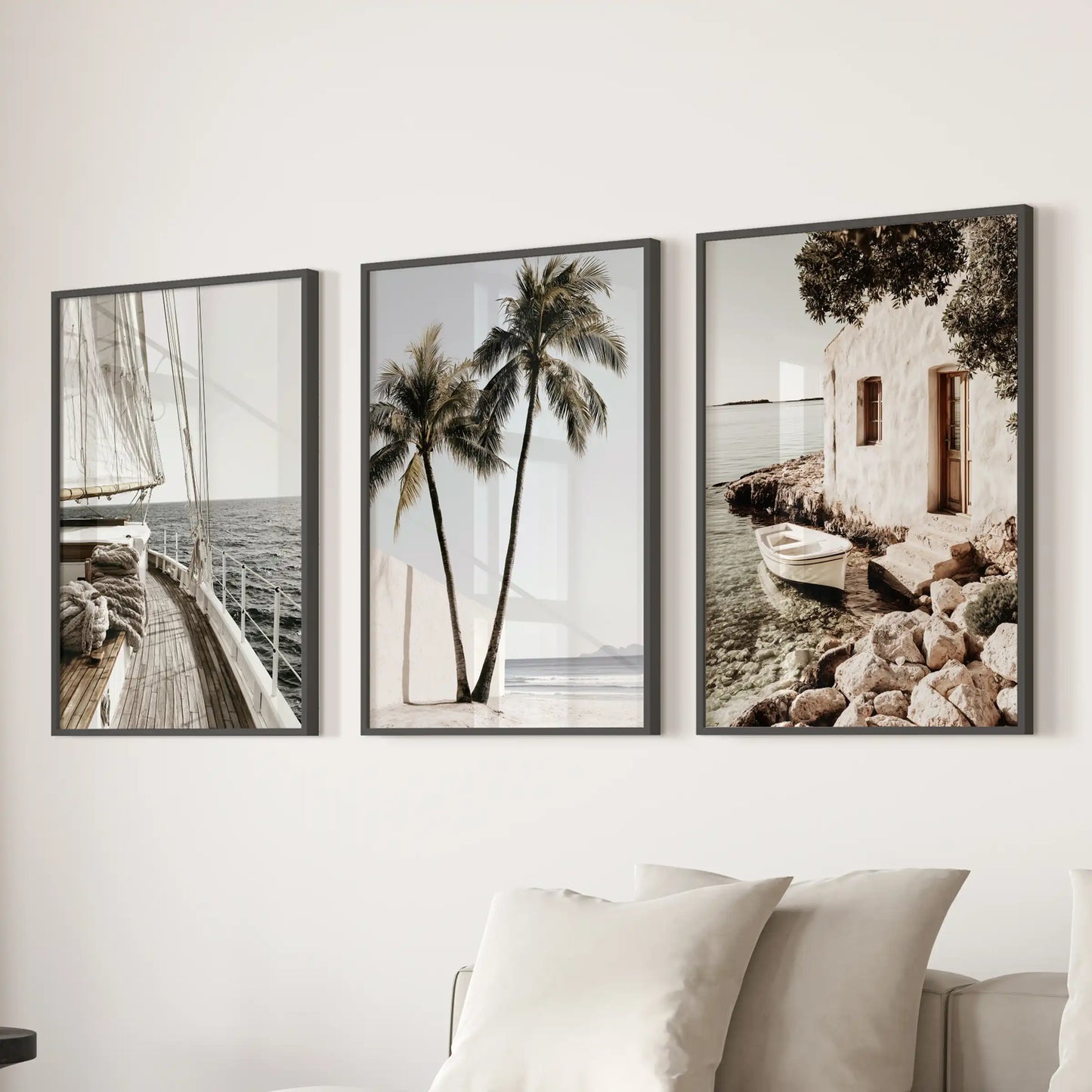 Mediterranean coastline wall art, three-print set in black frames, elevates the sitting room behind the sofa with sunlit shore views.