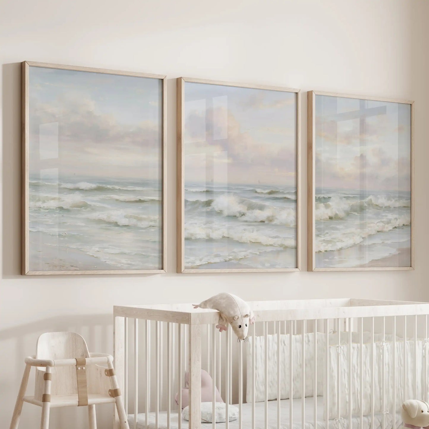 A wall art set of three sandy shoreline prints in light wood frames adds cozy coastal warmth to the nursery above the crib.