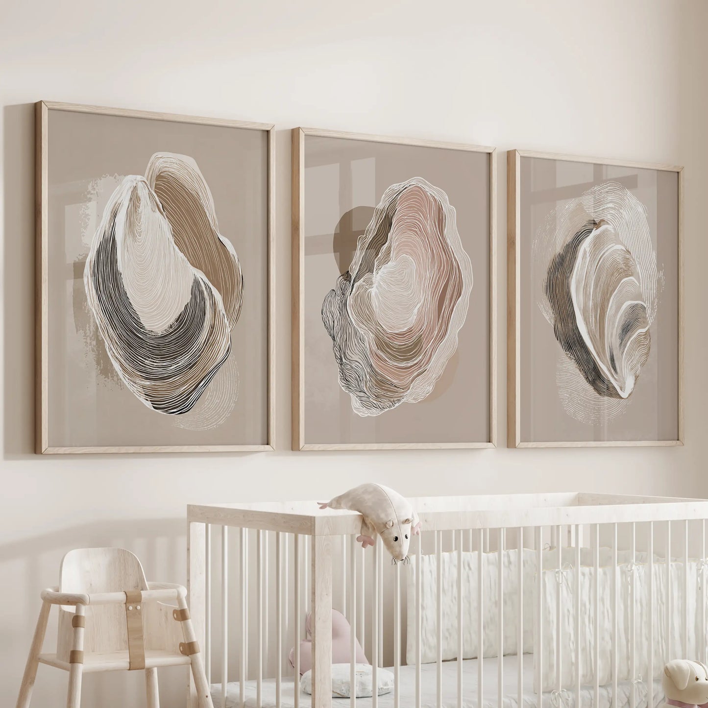 Vintage marine shell studies, a set of three wall decor prints in light oak frames, hover over the crib to add soft, beachy warmth to the baby room.