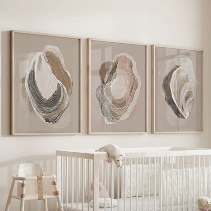 Vintage marine shell studies, a set of three wall decor prints in light oak frames, hover over the crib to add soft, beachy warmth to the baby room.