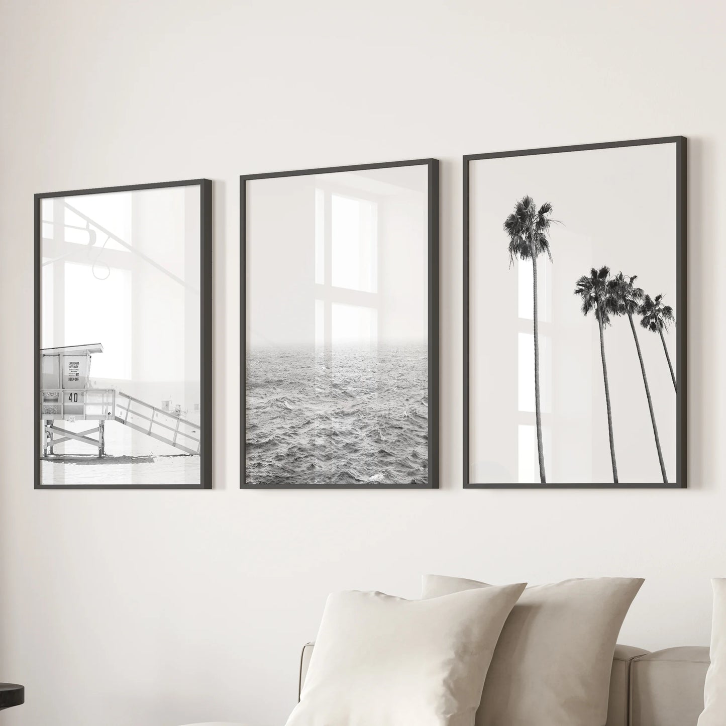 A three-piece black-framed wall art set featuring a lifeguard tower scene adds graphic coastal flair above the family-room sectional.