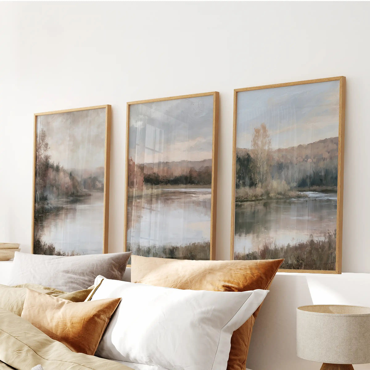 An oak-framed wall art set of three lakeside forest scenes centers above the bedroom bed, creating a peaceful, nature-forward focal point.