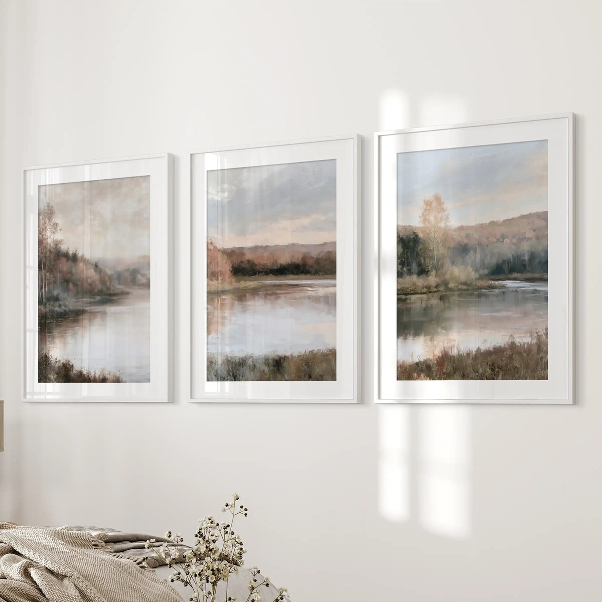 The three-piece picture set of autumn lake landscapes settles beside the bed, matted in white frames for a light, tranquil bedroom finish.