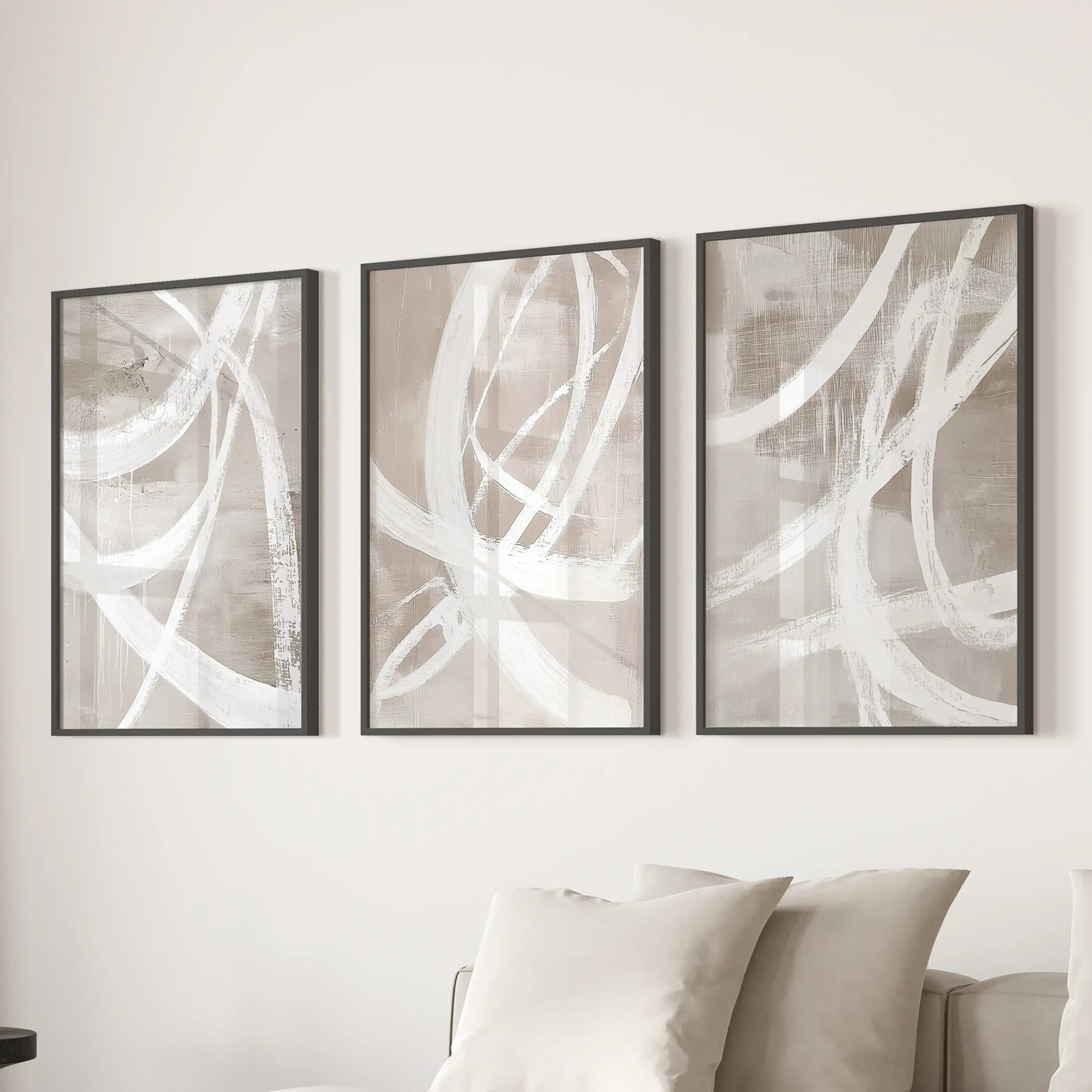 Set of three wall pieces featuring soft organic shapes in matte black frames gently align behind the living-room sofa.