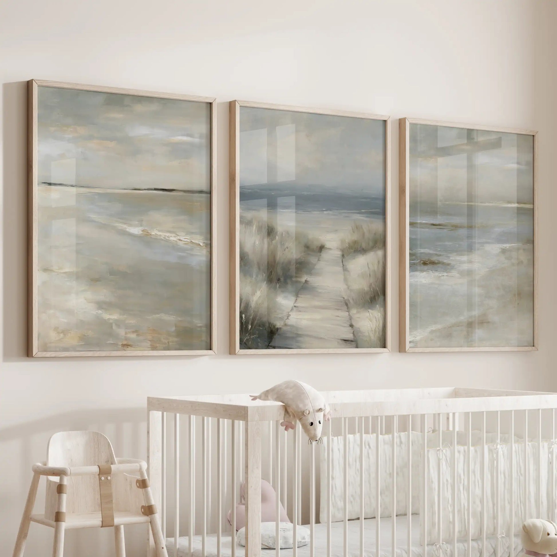 Oak-framed posters of neutral coastal landscapes, a set of three, hang above the bassinet bringing gentle sandy hues to the baby room.