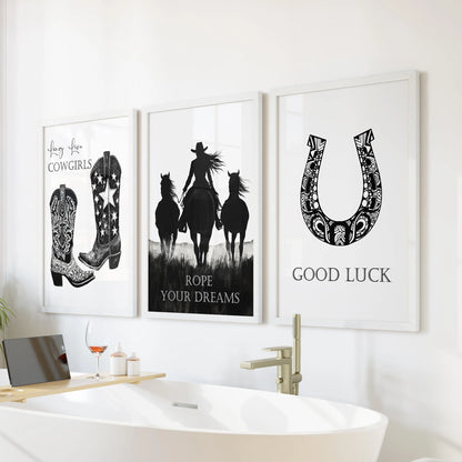 Wild West collage posters in a trio of wall art pieces sit in crisp white frames, adding a light Southwestern vibe above the bathtub in a fresh bathroom.