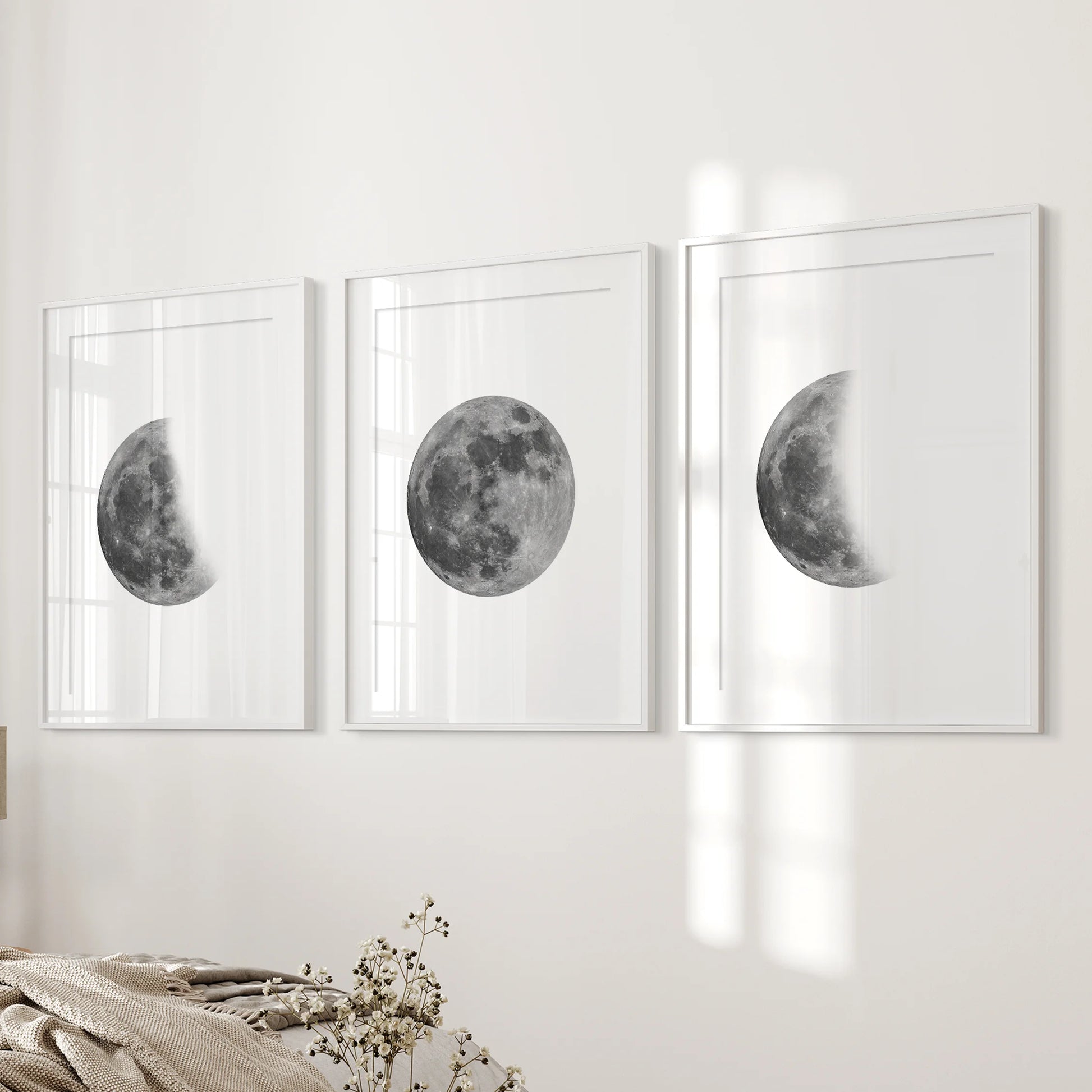 Three matted white-framed moon posters hang beside the bed, giving the bedroom a calm, gallery-like lunar finish.