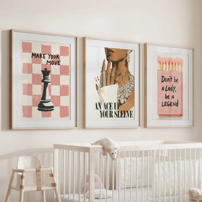 Fashion illustration wall art set of three in wood frames with matting, displayed over the cot in a nursery room.