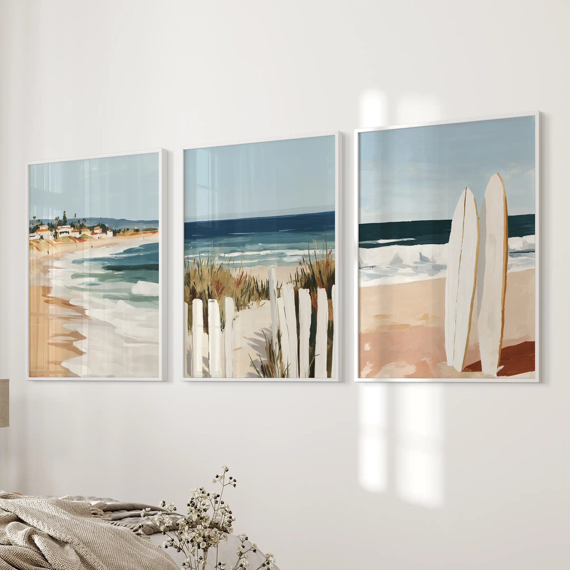 Sandy shoreline set of 3 wall art prints in crisp white frames settles onto a bedroom wall, lending soft sea-and-sand color to the space.