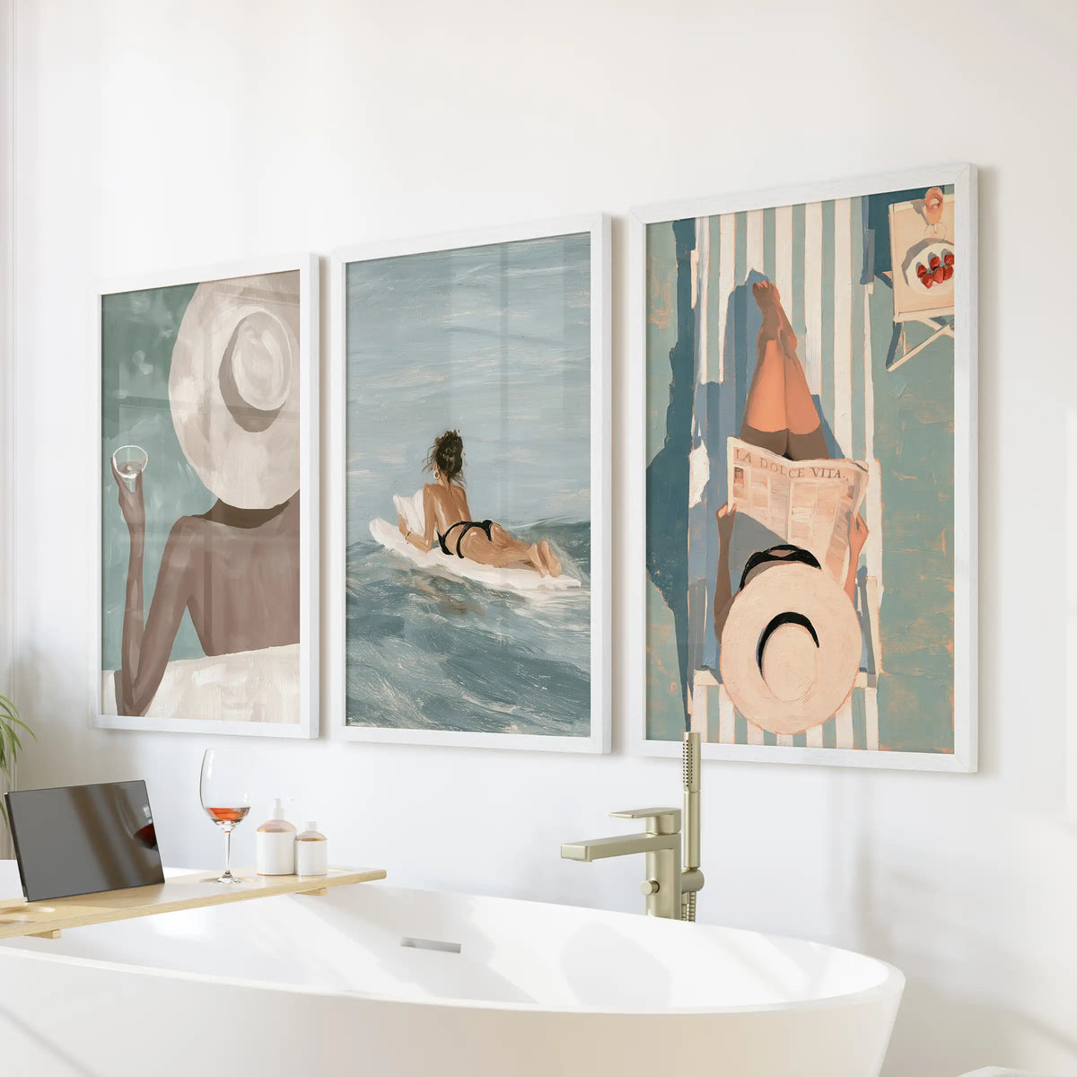 Summer surf three-poster wall art bundle in white frames, hanging above a soaking tub in a bathroom.