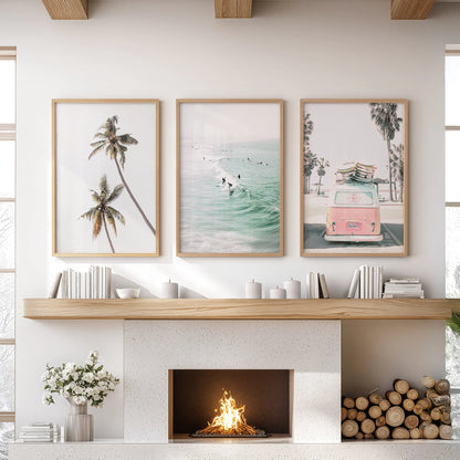 A palm-lined coastline print trio in warm wood frames anchors the sitting room wall, neatly arranged above the mantelpiece.