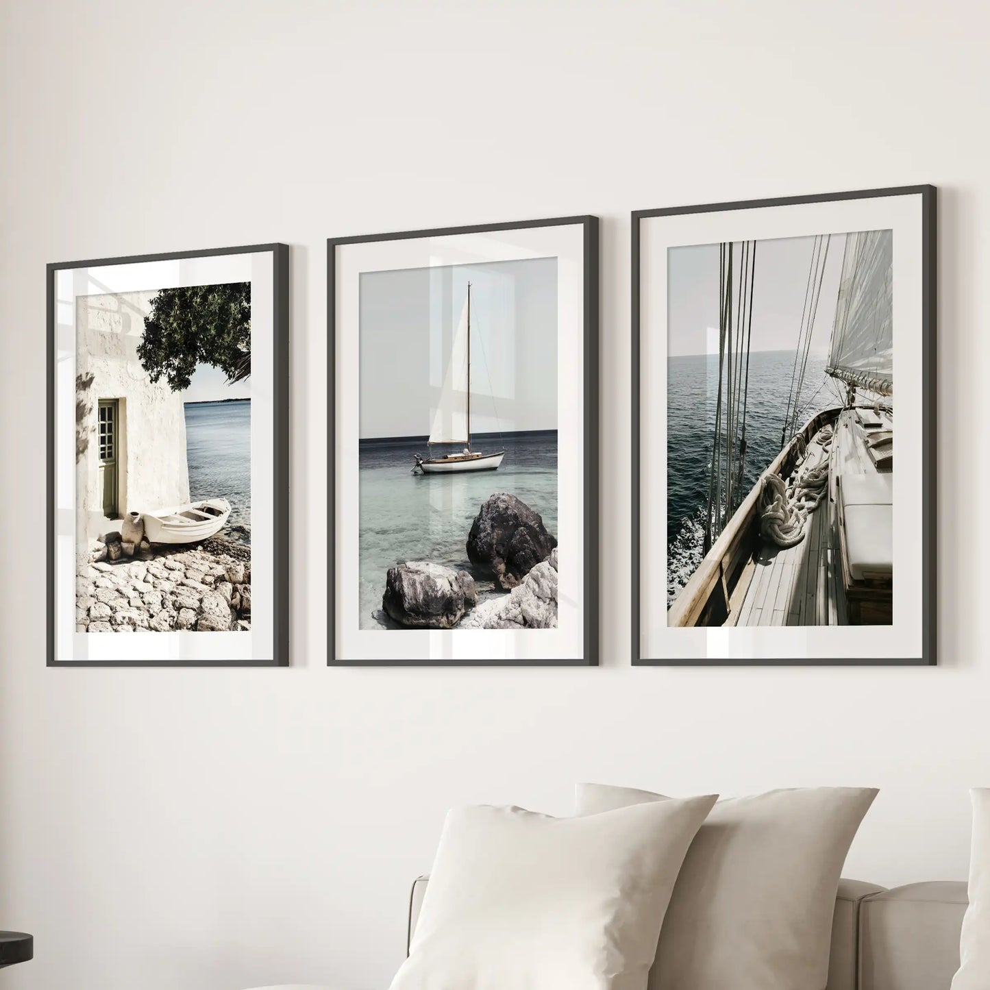 A picture set of 3 featuring the Riviera coastline lines up above the lounge sofa in black frames with white mats for a refined, breezy look.