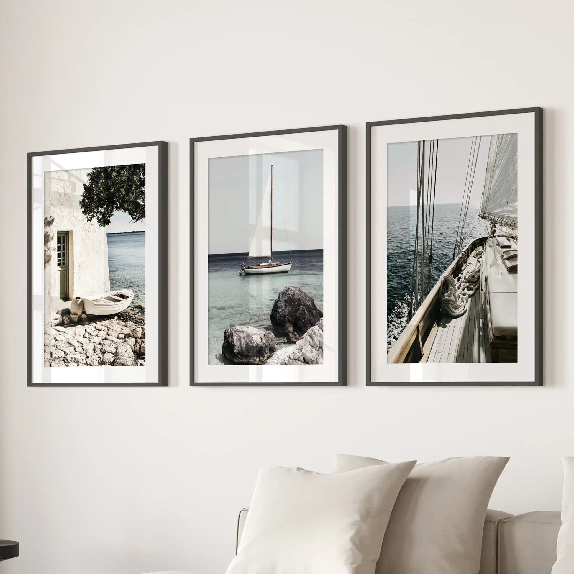 A picture set of 3 featuring the Riviera coastline lines up above the lounge sofa in black frames with white mats for a refined, breezy look.
