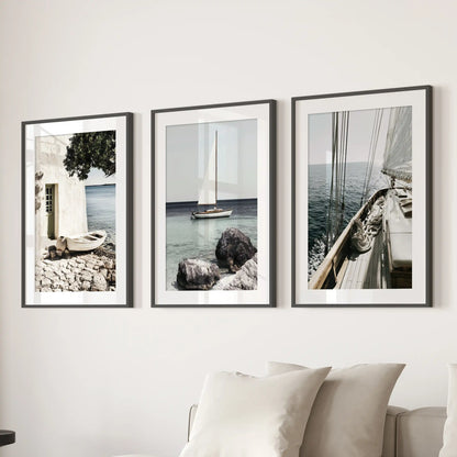 A picture set of 3 featuring the Riviera coastline lines up above the lounge sofa in black frames with white mats for a refined, breezy look.