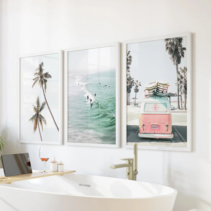 Palm tree coastline three-piece wall art set freshens the bathroom, with crisp white frames positioned serenely over the bathtub.