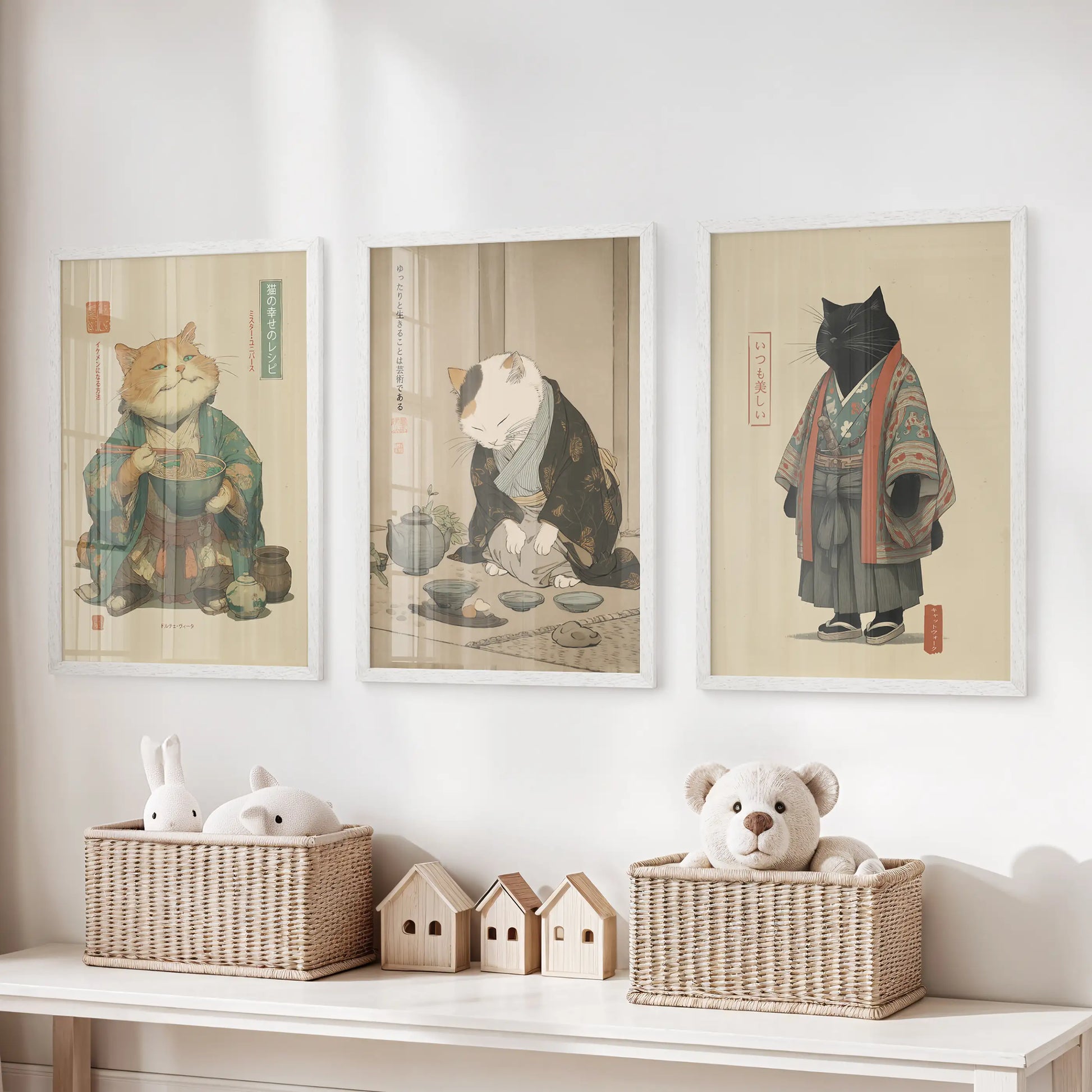 In the playroom, three bright white cat prints depicting a tea ceremony line the wall above toy storage, quietly whimsical yet calm.