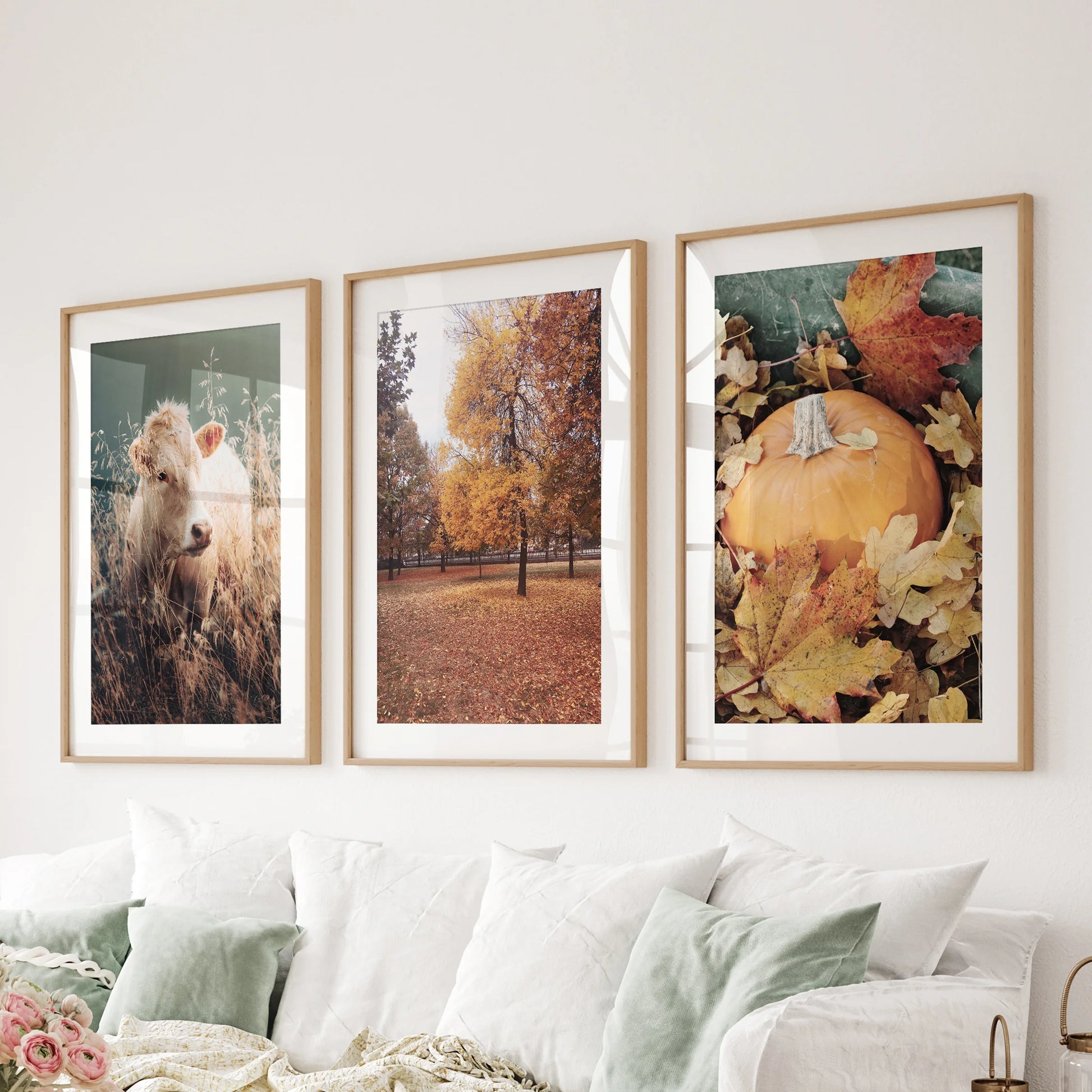 A set of three matted prints in wooden frames adds relaxed Thanksgiving charm to the sitting room wall behind the sofa.