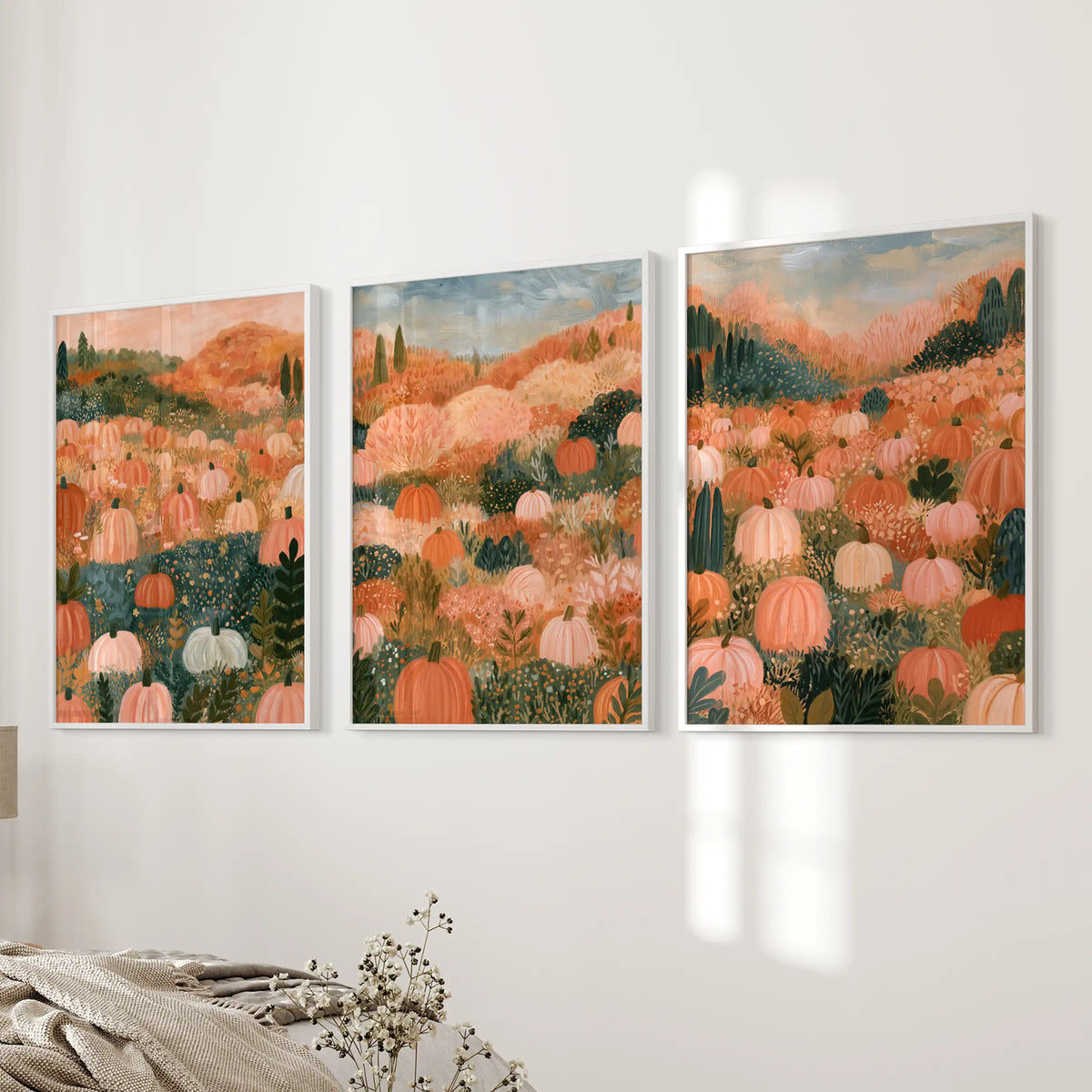 Three framed wall prints in white depict a cottagecore harvest scene, settling beside the bed with soft seasonal warmth.