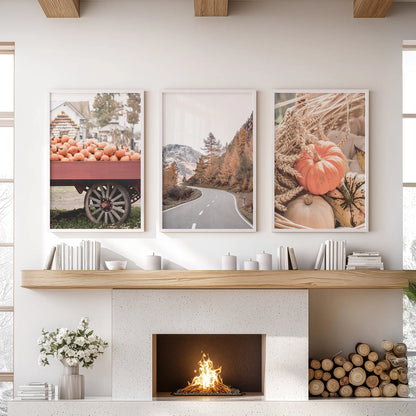 A fall farmhouse scene in three white-framed decor pieces hangs over the living room mantel, blending harvest warmth with uncluttered charm.