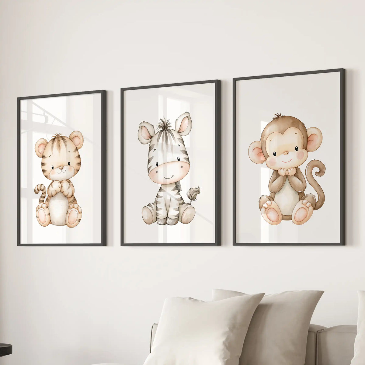 Black frames surround three prints above a sofa: a tiger cub at left, a striped zebra in the middle and a brown monkey at right.