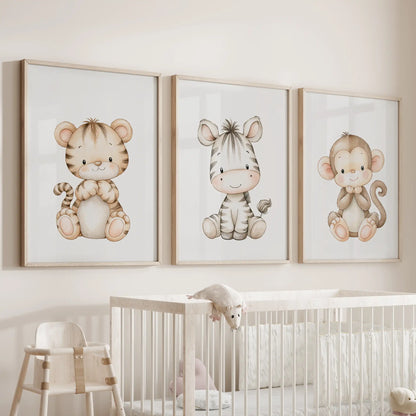 Three tiger, zebra and monkey prints in oak frames above a nursery crib.