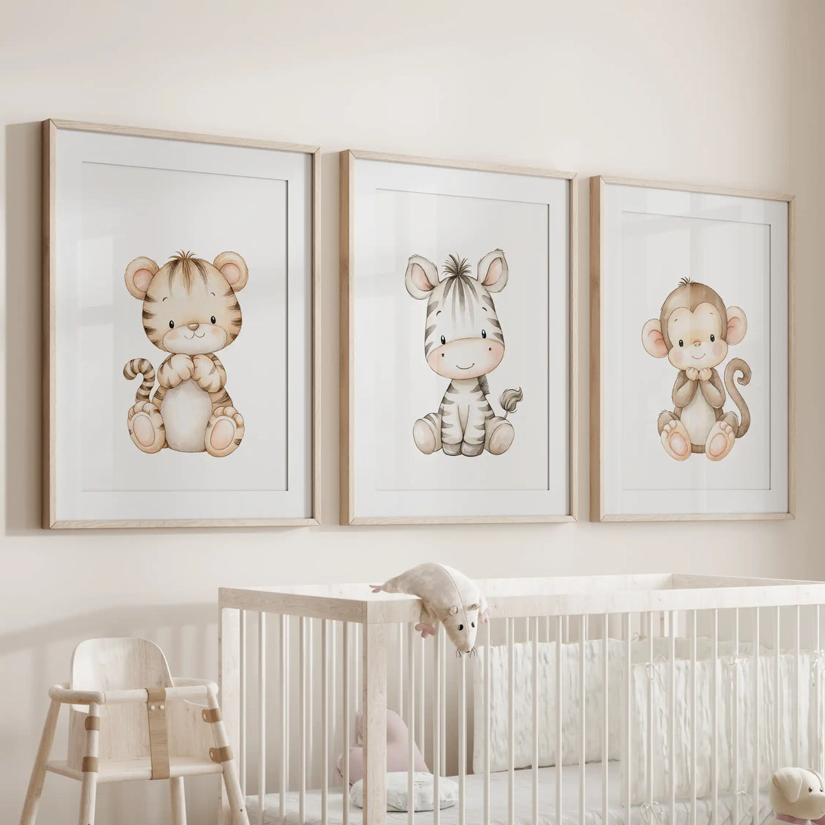 A set of three tiger, zebra and monkey prints in oak frames with white mats above a crib.
