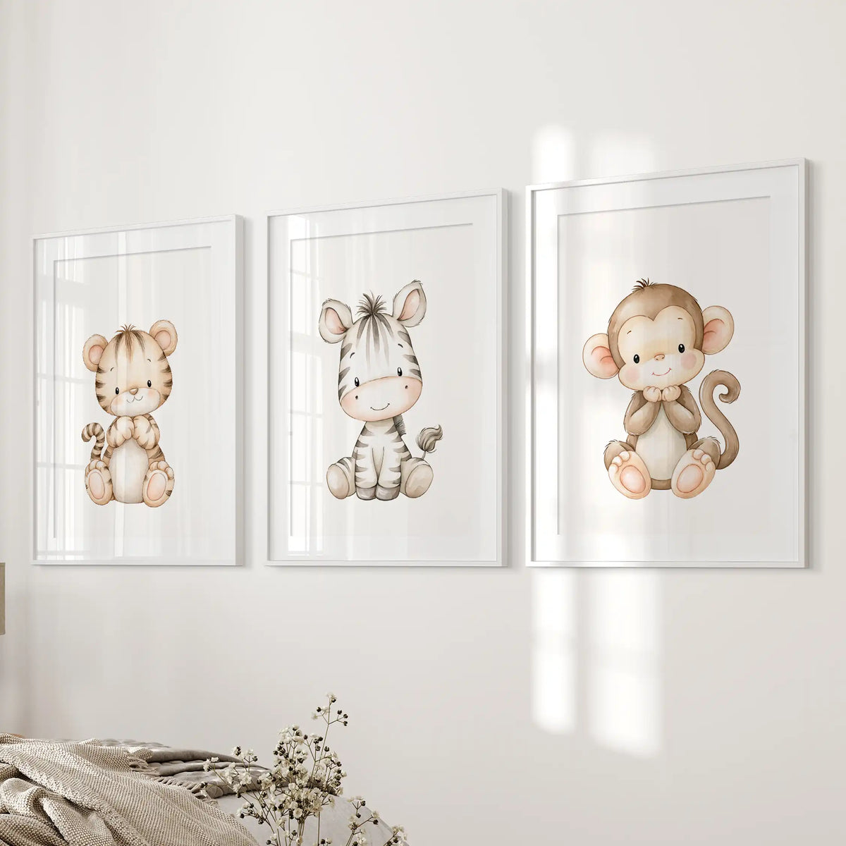 Beside a bed, three prints in matted white frames show a seated tiger cub, zebra and monkey on plain white backgrounds.