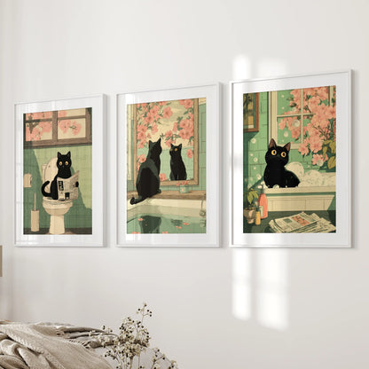 This three-panel wall art shows a toilet-reading black cat in white framed prints with mats, displayed beside the bed for subtle humor.