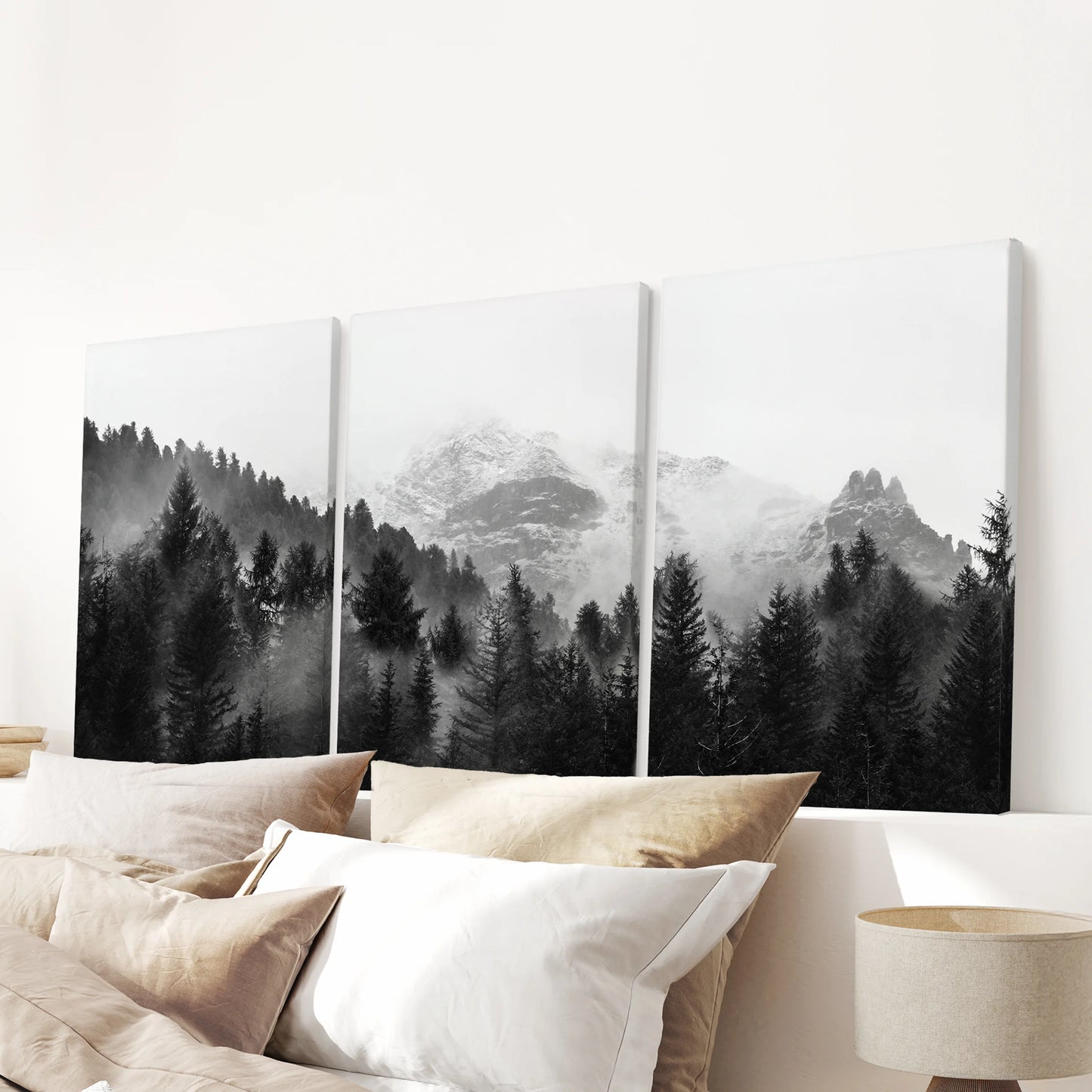 Gallery-wrapped canvas wall art in three panels shows a foggy mountain forest, centered calmly above a bedroom headboard.