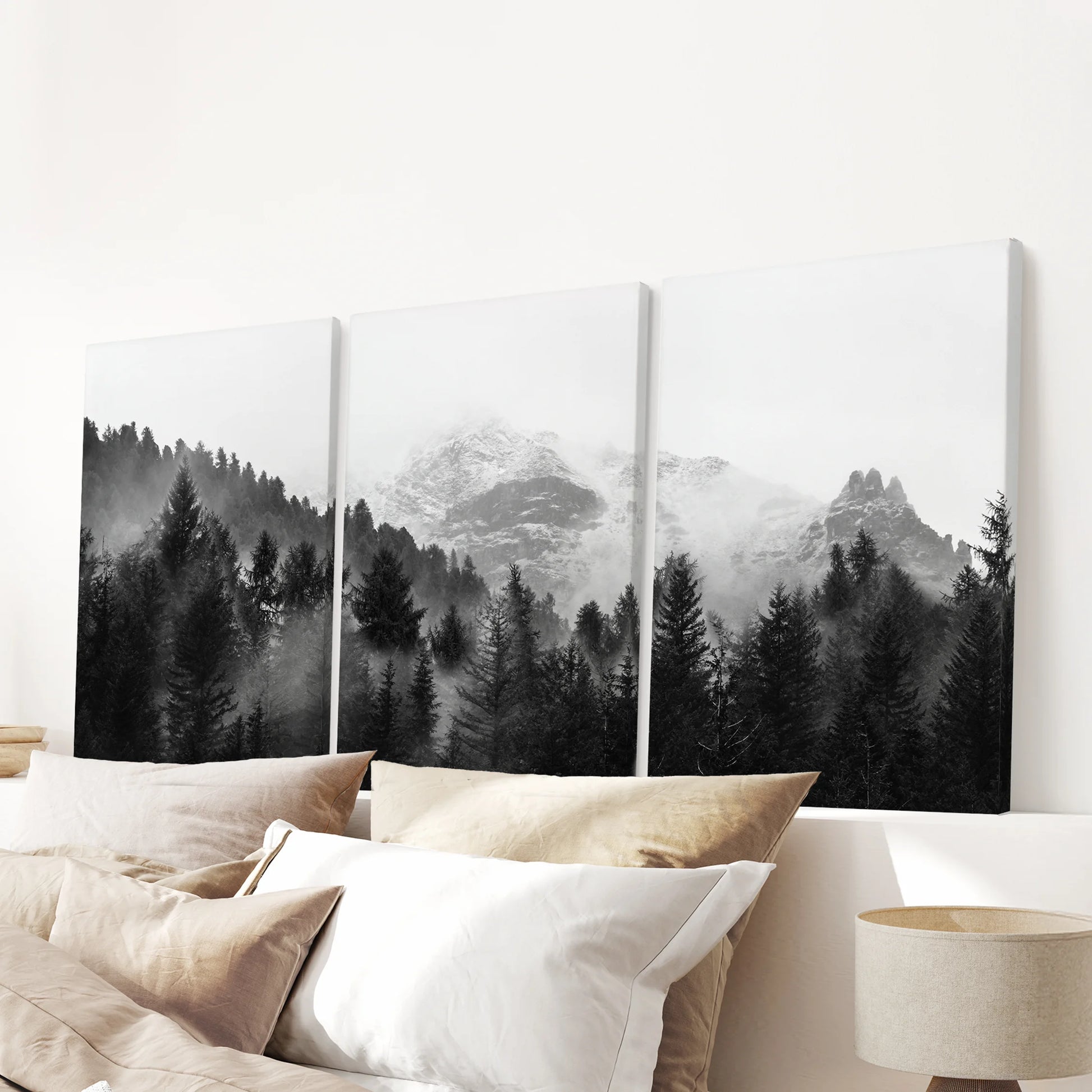 Gallery-wrapped canvas wall art in three panels shows a foggy mountain forest, centered calmly above a bedroom headboard.