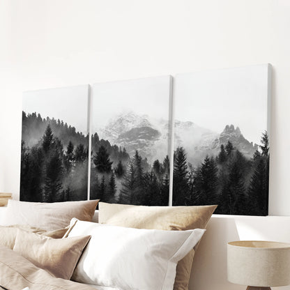 Gallery-wrapped canvas wall art in three panels shows a foggy mountain forest, centered calmly above a bedroom headboard.