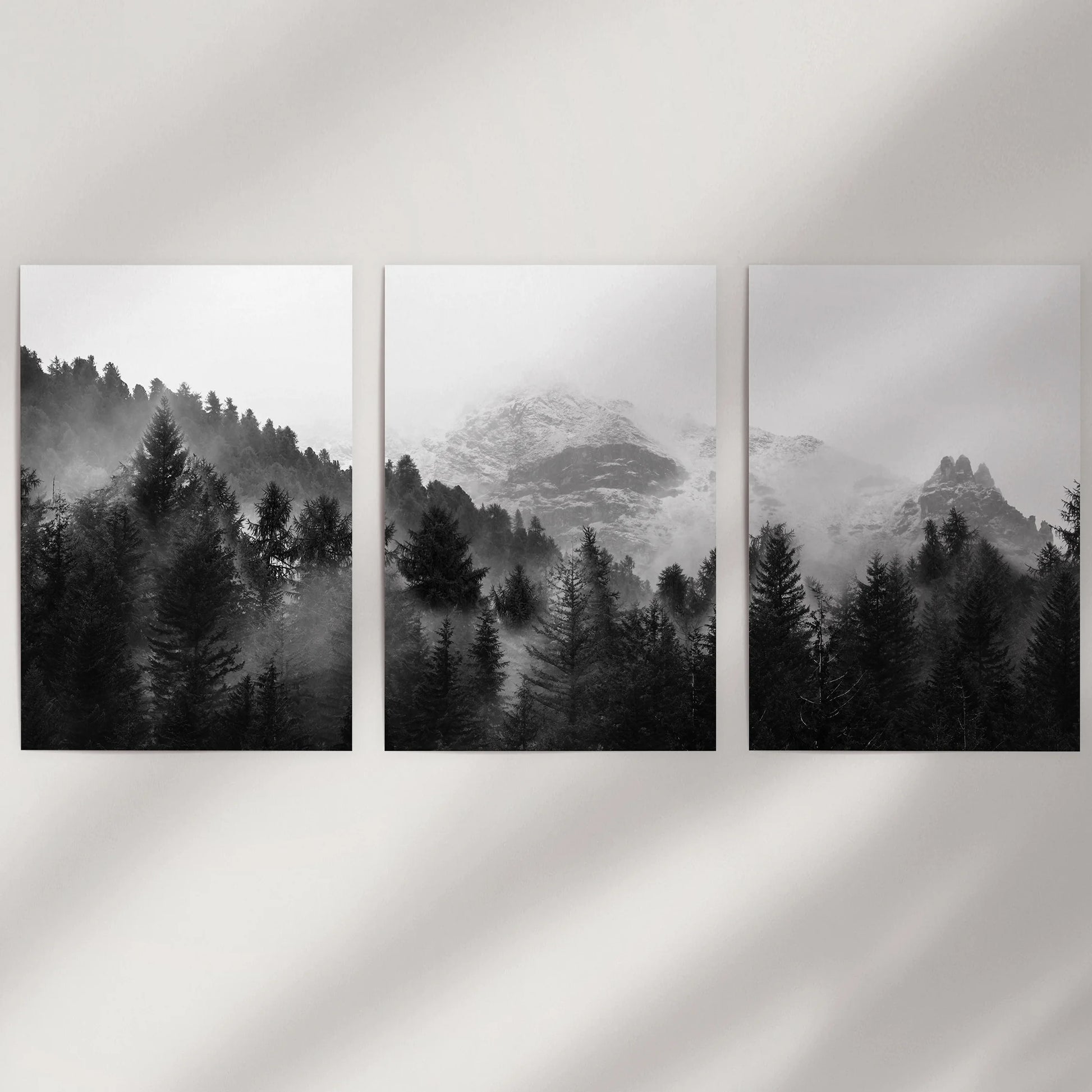 A minimalist trio of unframed woodland art prints in monochrome adds quiet Nordic depth to empty wall space.