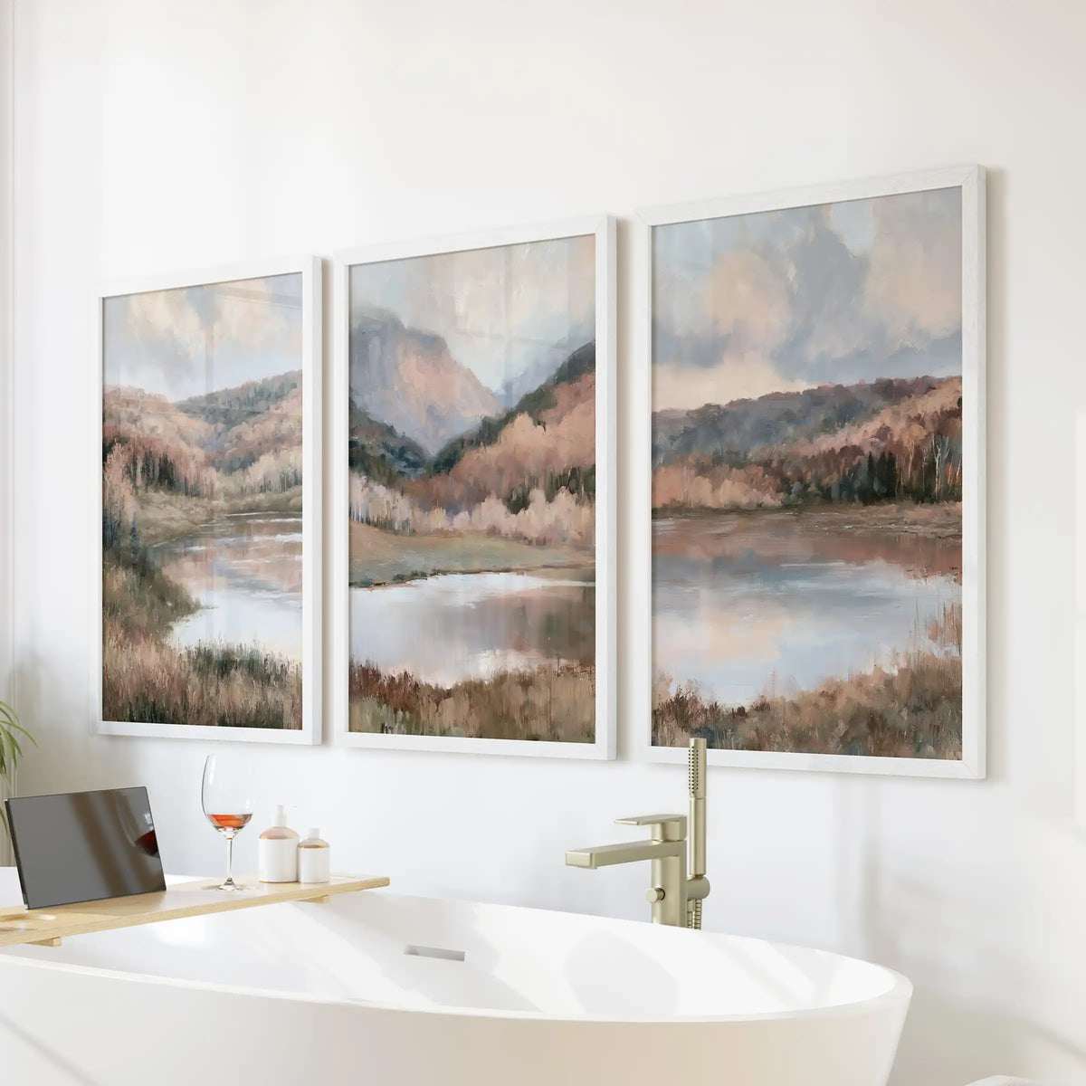 Three white-framed pictures of impressionist lake landscapes hang over the freestanding bathroom tub, lending the space a breezy, spa-calm nature view.