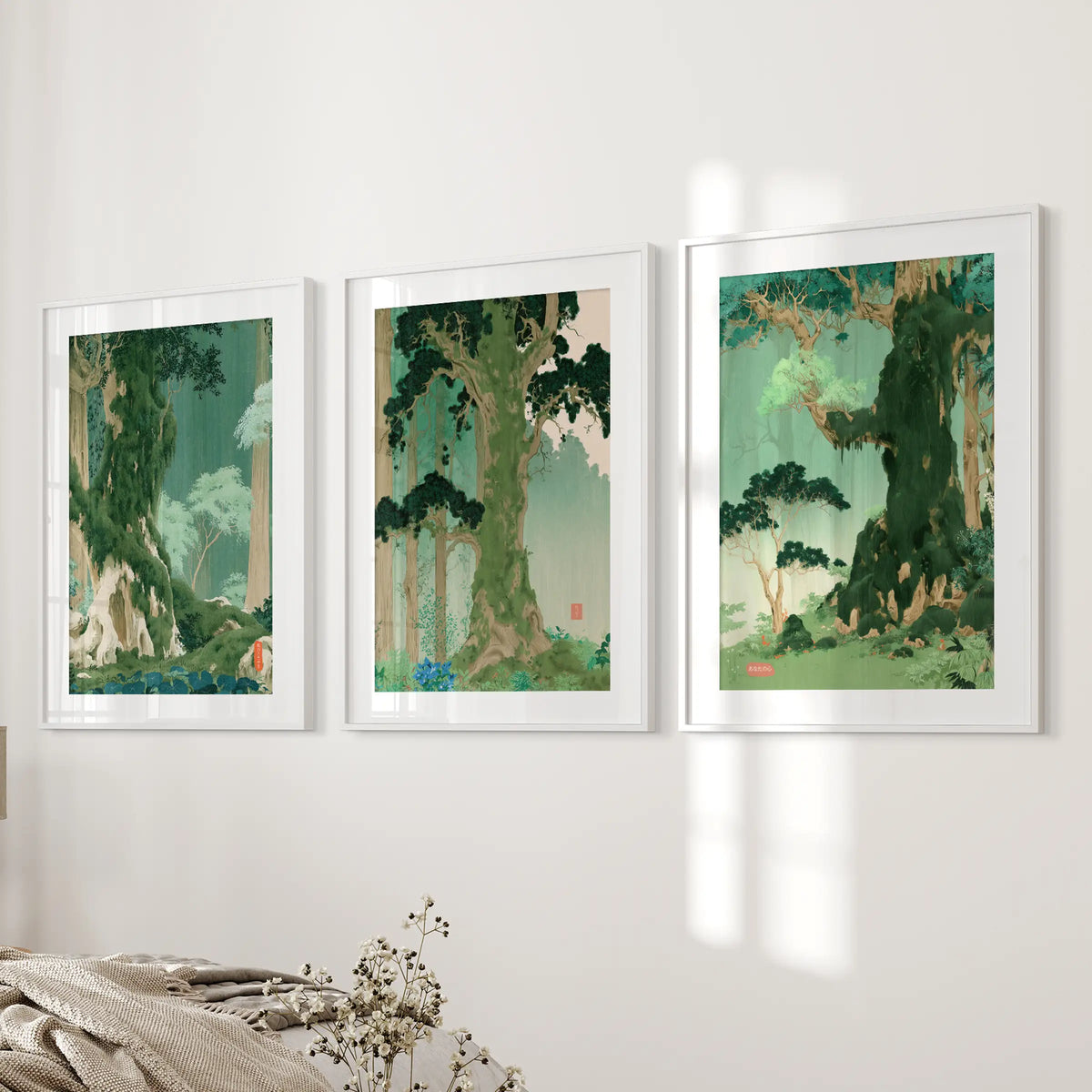 A set of three woodland landscape pictures in white matted frames hangs on the bedroom wall next to the bed.