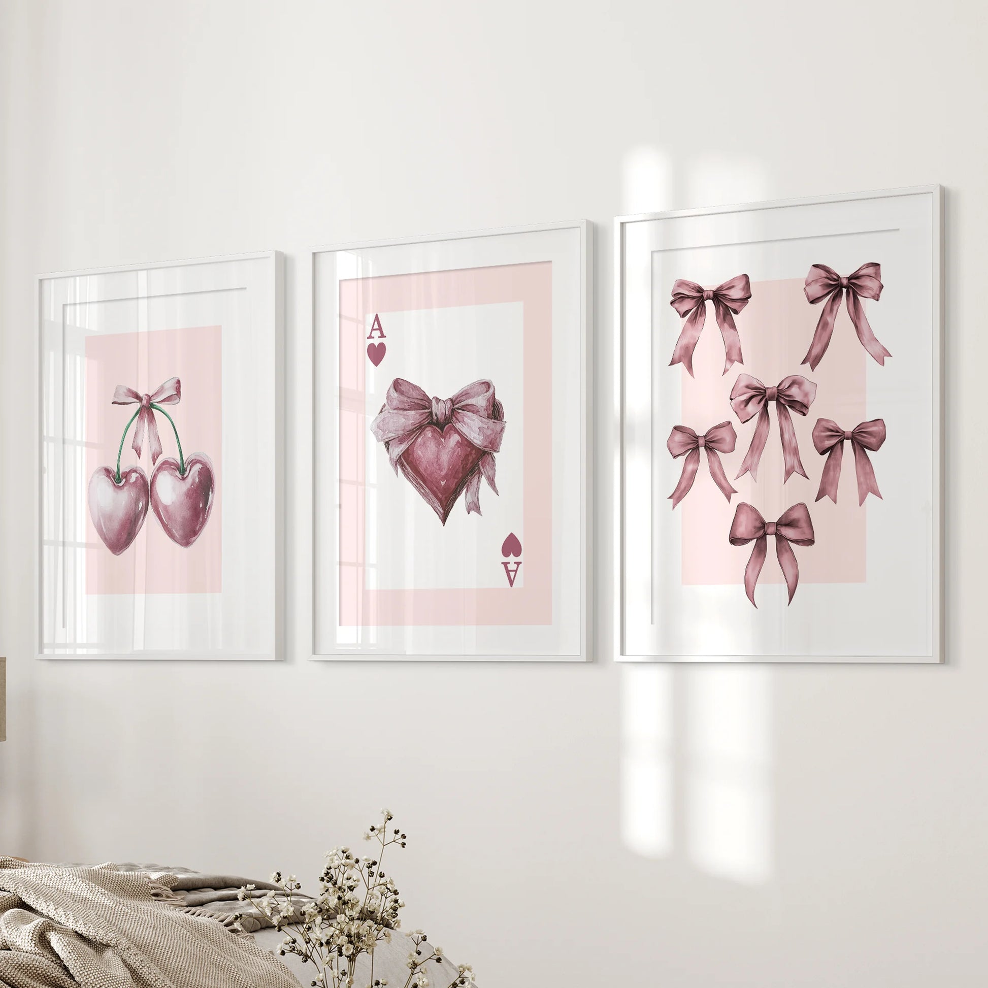 Coquette icon trio 3-piece wall art set-ace, bows, cherries-in white frames with mats hangs beside the bed, tying the bedroom palette together.