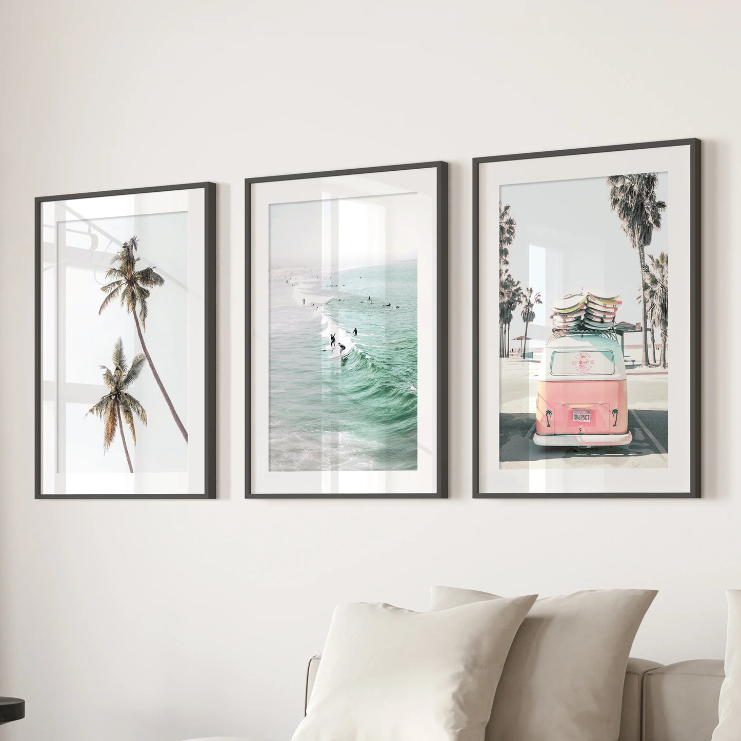 Rolling ocean surf three-panel artwork calms the family room, presented in black matted frames and centered over the sectional sofa.