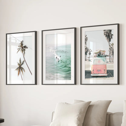 Rolling ocean surf three-panel artwork calms the family room, presented in black matted frames and centered over the sectional sofa.