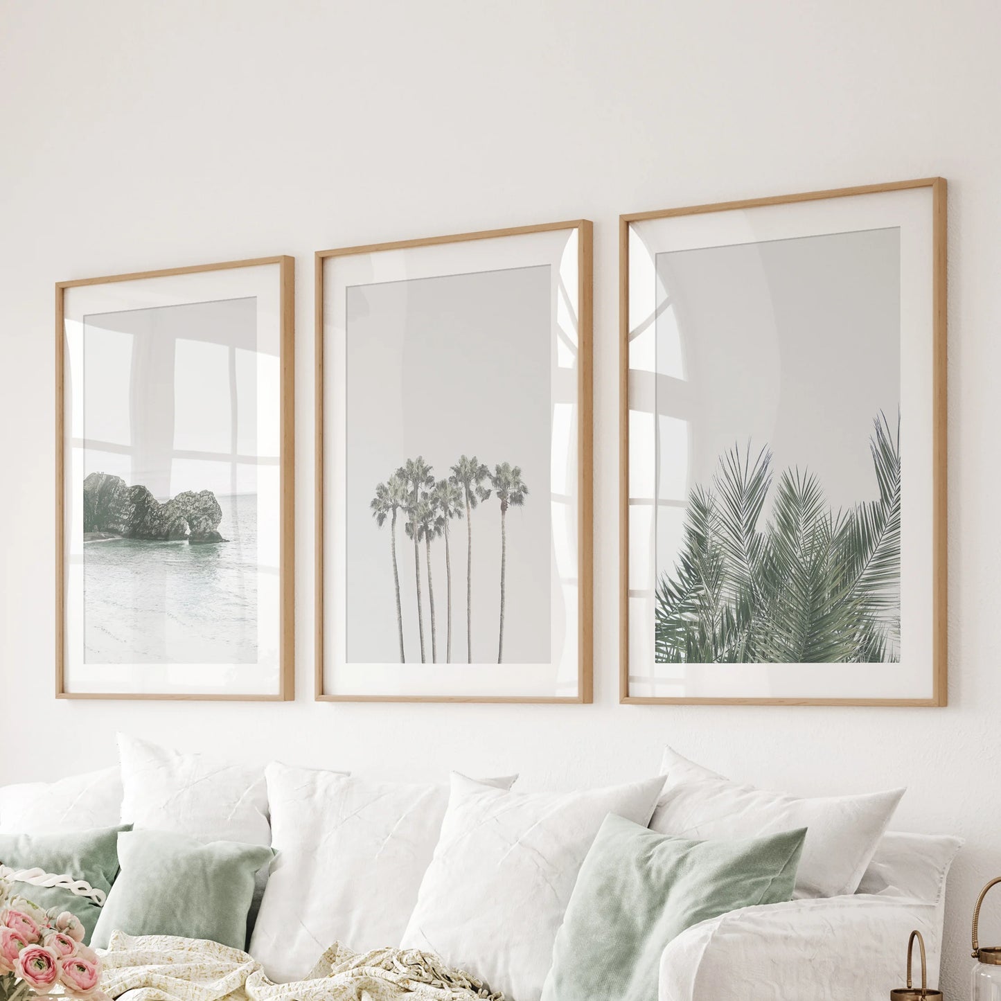 Three oak-matted art prints of a tropical sunset brighten the living room, forming a tranquil lineup above the sofa.