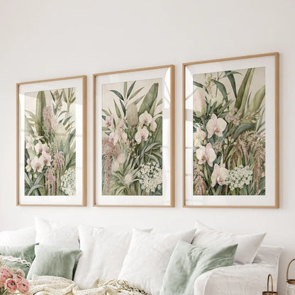 The three prints above a sofa show pale pink orchids among overlapping leaves, framed in oak with white mats around the dense greenery.