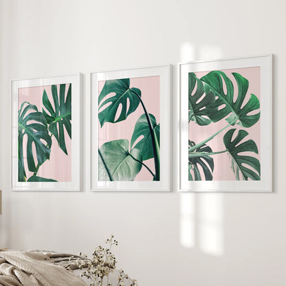 Framed in white with matting, this three-piece set of pink tropical plant prints stretches beside the bed as airy, modern wall art.