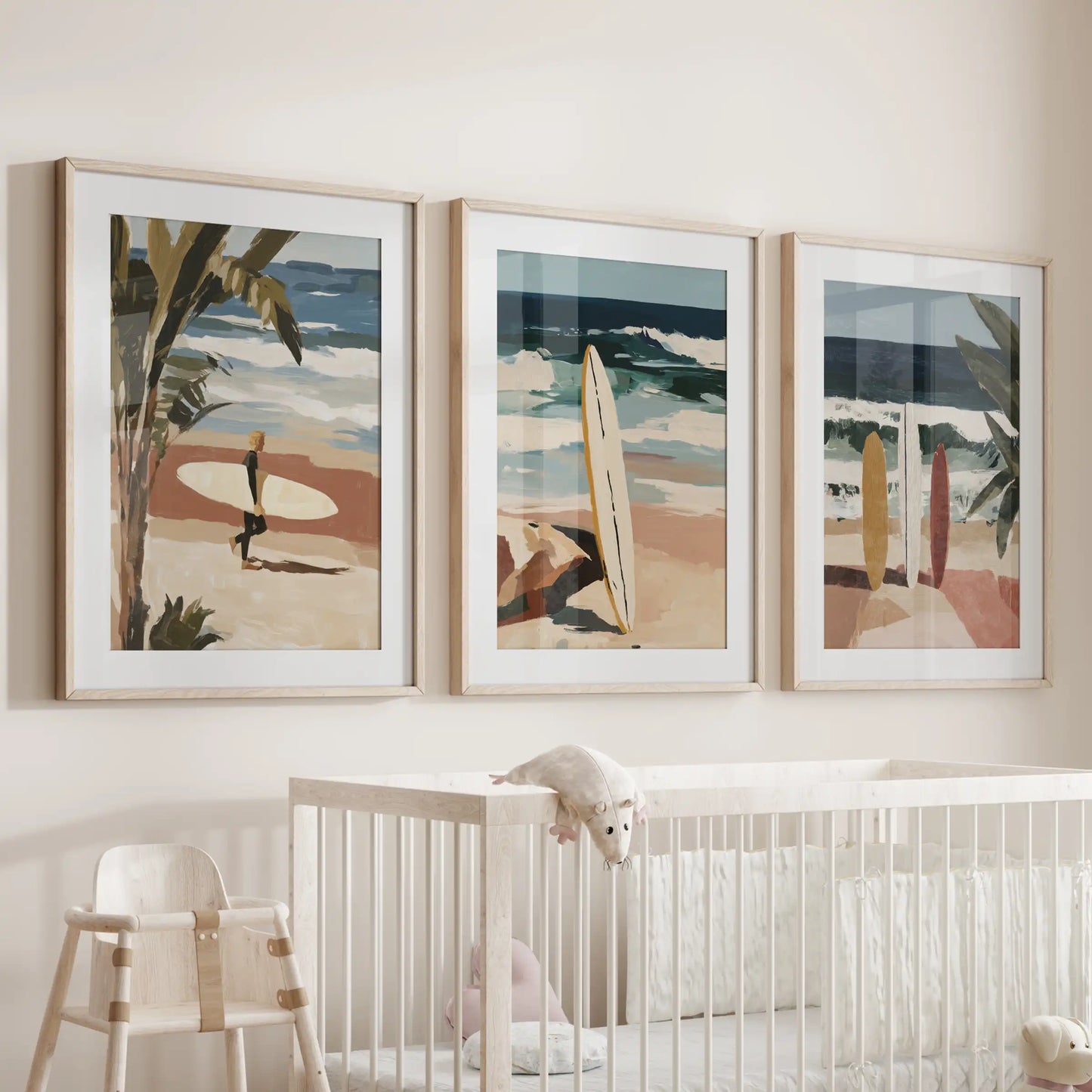 A three-print surfboard wall art set in natural oak frames with mats accents the nursery above the crib with warm coastal color.