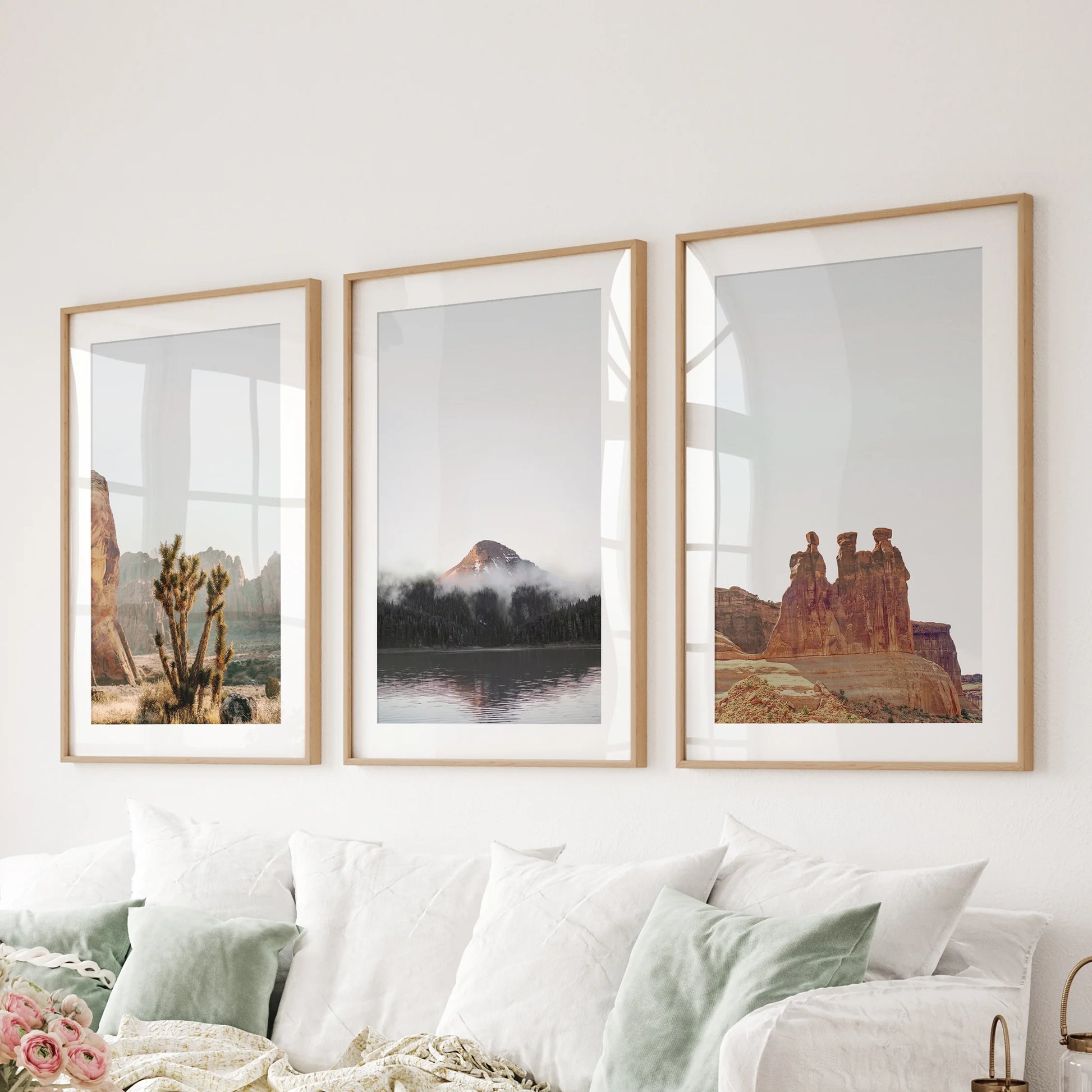 Boho desert scenery three-print wall art set in natural wood frames with mats completes the family room, aligned neatly behind the sofa.