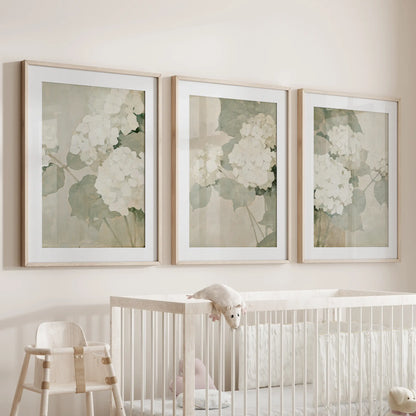 Three-piece hydrangea wall art set in matted oak frames, displayed over a crib in the nursery.