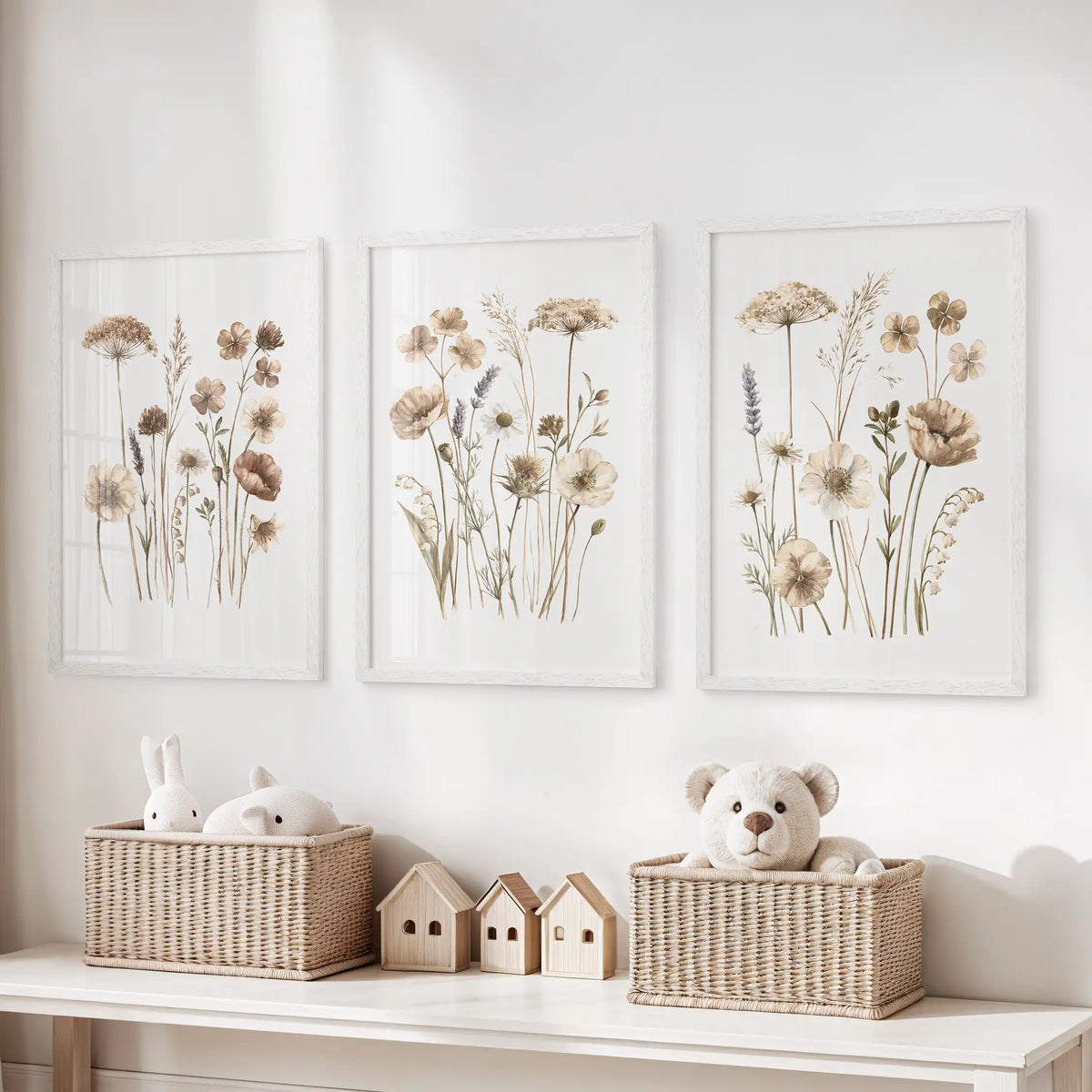 Fine stems and small beige flower heads fill three white-framed prints above baskets of toys, with open white backgrounds around the plants.