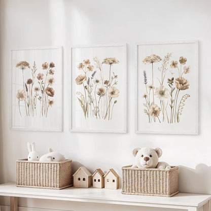 Fine stems and small beige flower heads fill three white-framed prints above baskets of toys, with open white backgrounds around the plants.