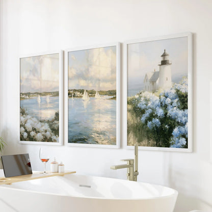 Wall decor featuring Nantucket sailboats comes as a three-piece set in soft white frames, bringing a calm coastal mood above the bathroom bathtub.