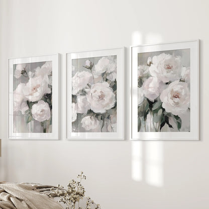 Abstract peony blossoms form a 3-piece artwork set, white-mat frames lining the bedroom wall beside the bed with painterly texture and quiet romance.