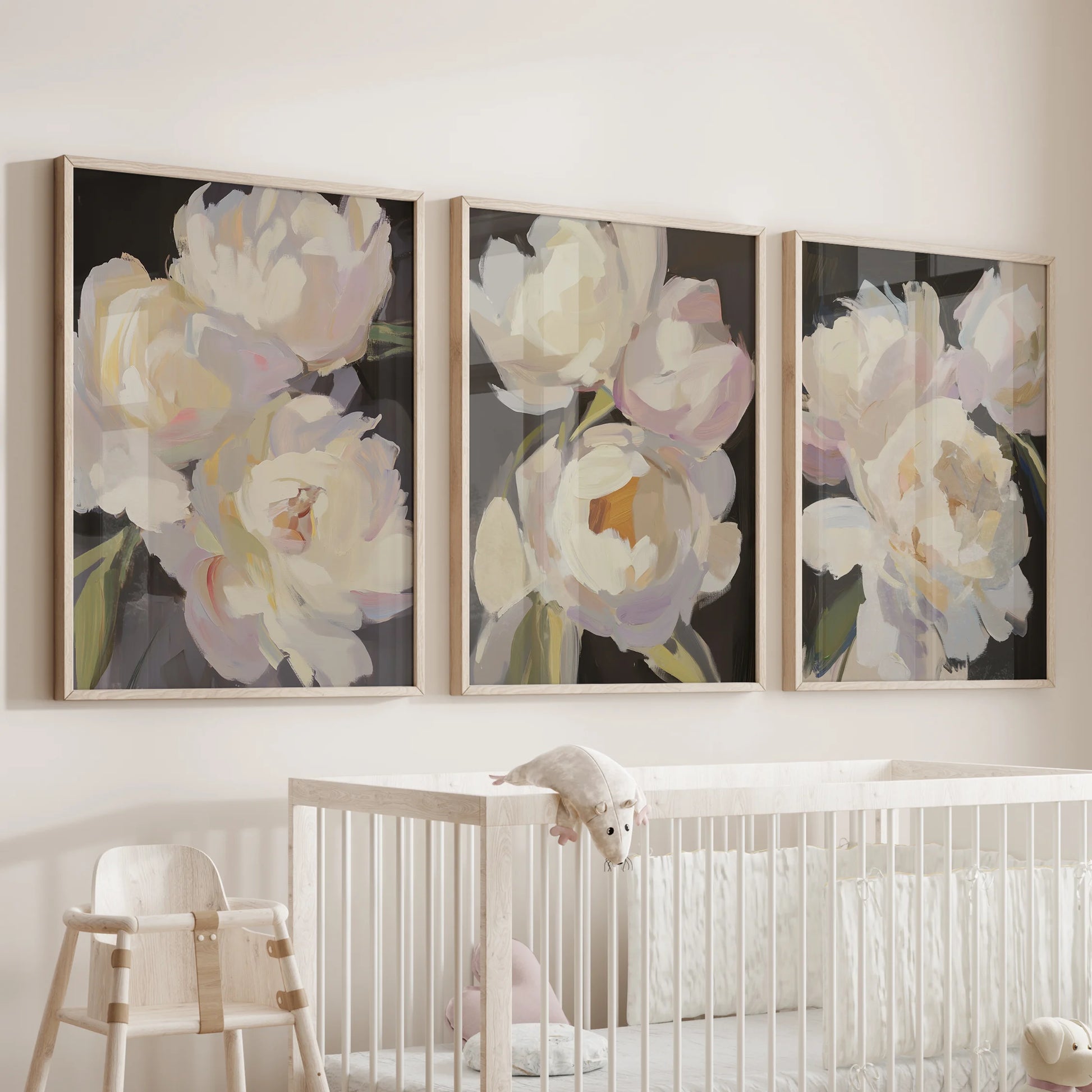 Vintage floral still lifes, a three-piece artwork set, hangs above the infant room crib in solid oak frames, soothing with dusky petals.